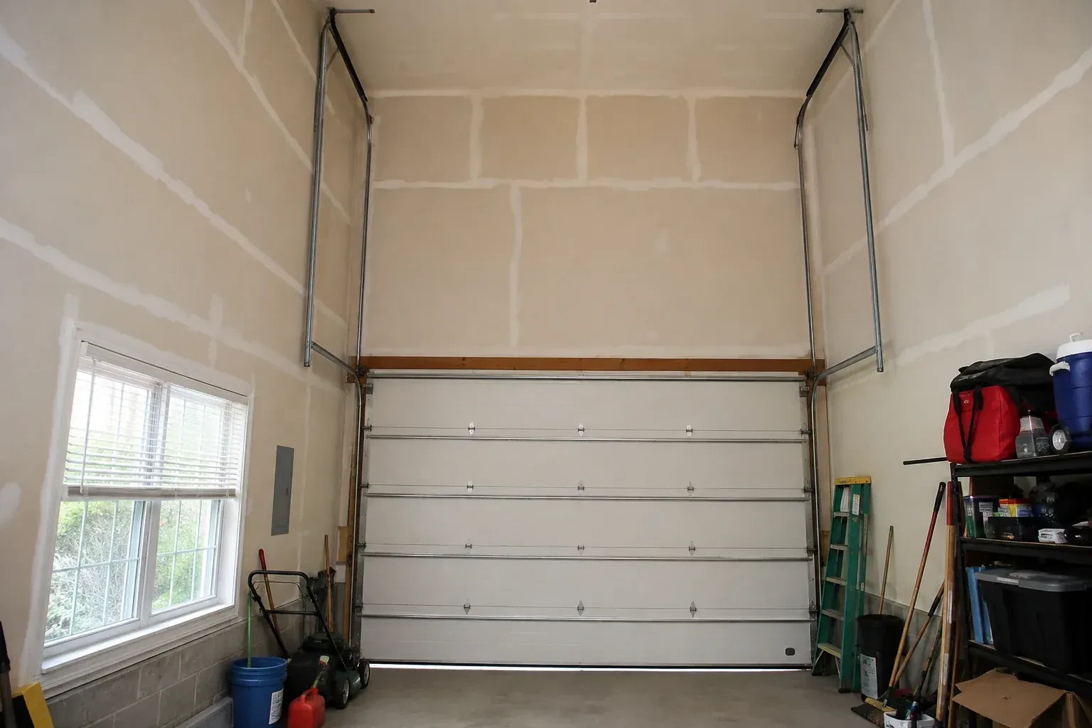Tall garage interior with a sectional door and tracks extending into overhead space. — High-Lift Garage Door Conversion, Richmond Hill